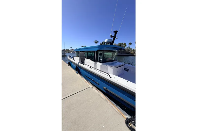 Slide: The Image of 2024 Axopar 37 XC Cross Cabin docked, showcasing sleek design and modern features. - 16