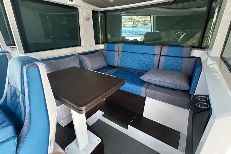Slide: The Image of 2024 Axopar 37 XC Cross Cabin interior with blue seating and dining table. - 4