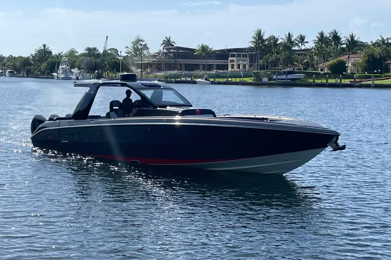 The Image of 2023 Cigarette 41' Nighthawk boat cruising on a sunny waterfront. - 1