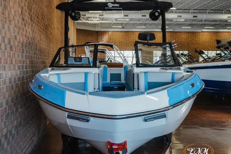 Slide: The Image of 2024 Malibu Wakesetter 23 LSV boat in showroom, featuring sleek blue and white design. - 3