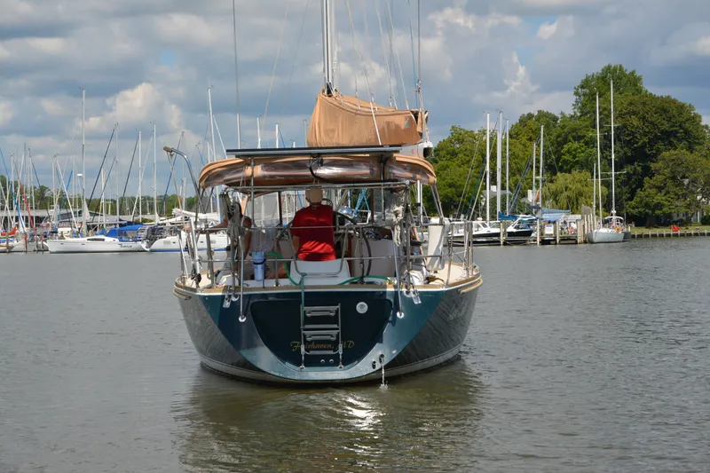Slide: The Image of Sailing yacht Sabre 402, 2002 model, navigating a marina with moored boats. - 8