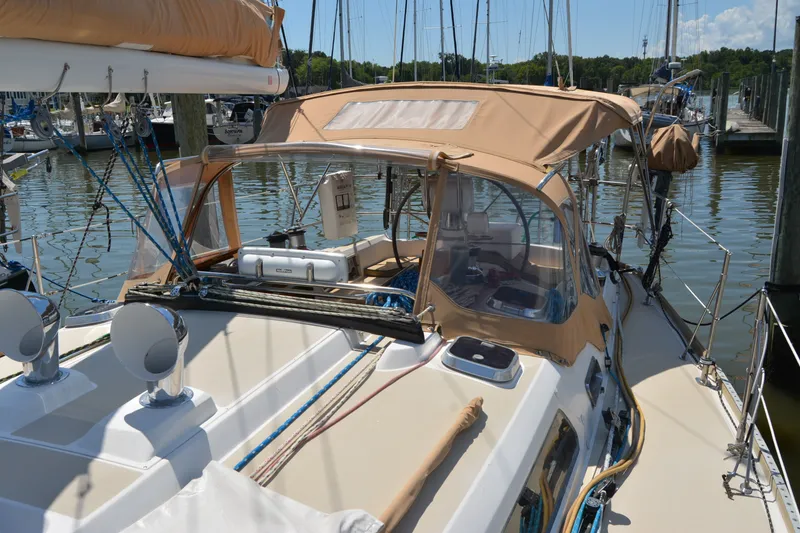 Slide: The Image of 2002 Sabre 402 sailboat docked, featuring tan canvas covers and polished deck fittings. - 45