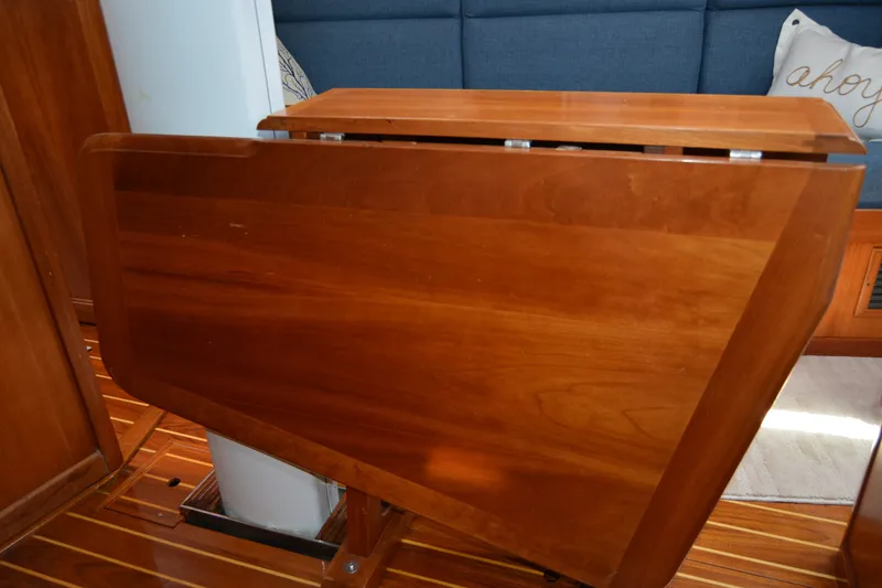 Slide: The Image of Wooden interior table on a 2002 Sabre 402 yacht, with blue seating and nautical decor. - 105