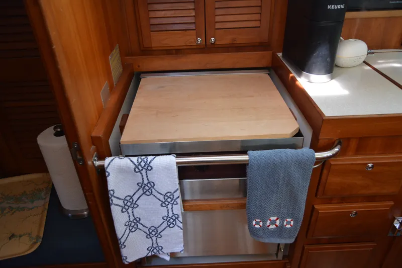 Slide: The Image of Wooden interior of a 2002 Sabre 402 yacht kitchen with towels and appliances. - 84