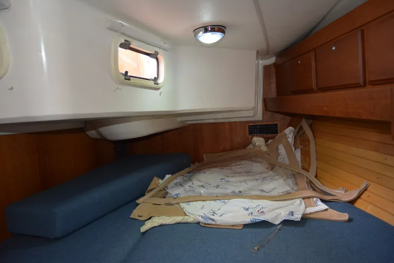 Slide: The Image of Cozy cabin interior of 2002 Sabre 402 sailboat with blue cushions and wooden cabinetry. - 129