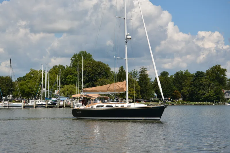 Slide: The Image of Sailboat Sabre 402 (2002) on calm water, with marina and trees in background. - 12