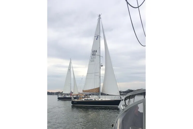 Slide: The Image of Sailboats on calm water, featuring a 2002 Sabre 402 under cloudy skies. - 22