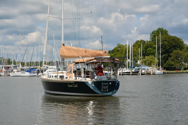 Slide: The Image of 2002 Sabre 402 sailboat on calm water near marina, under partly cloudy sky. - 9