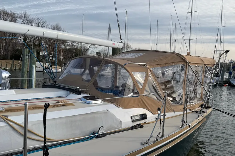 Slide: The Image of 2002 Sabre 402 sailboat docked, featuring a tan canopy and sleek design. - 51