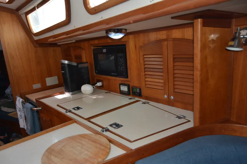 Slide: The Image of Wooden interior of a 2002 Sabre 402 yacht galley with appliances and storage. - 103