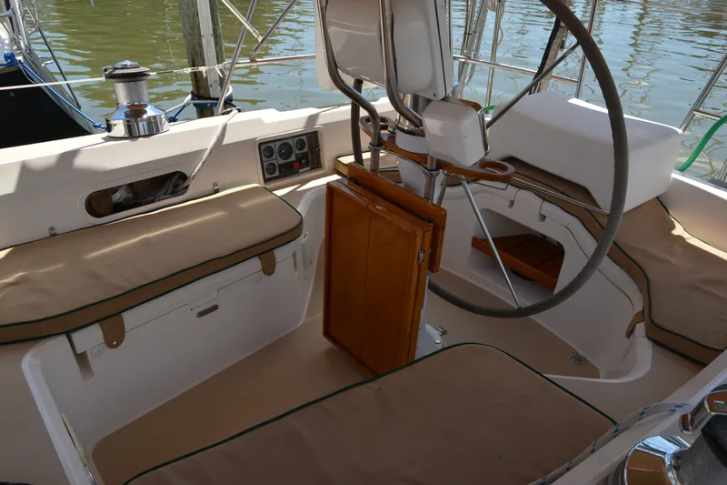 Slide: The Image of Cockpit of 2002 Sabre 402 sailboat with cushioned seating and steering wheel. - 54