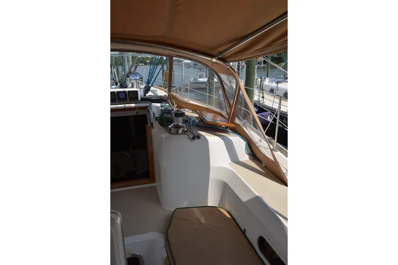 Slide: The Image of 2002 Sabre 402 sailboat cockpit with tan canopy and marina view. - 63