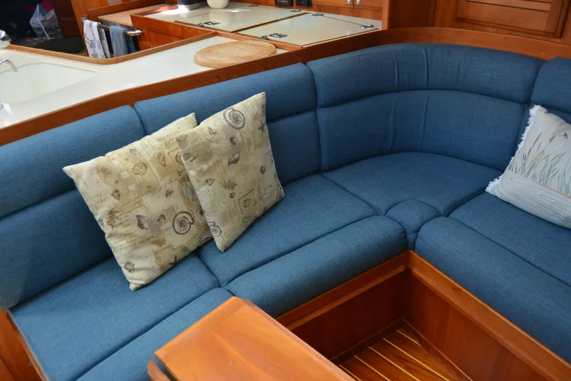 Slide: The Image of Blue cushioned seating area with decorative pillows in a 2002 Sabre 402 yacht interior. - 98