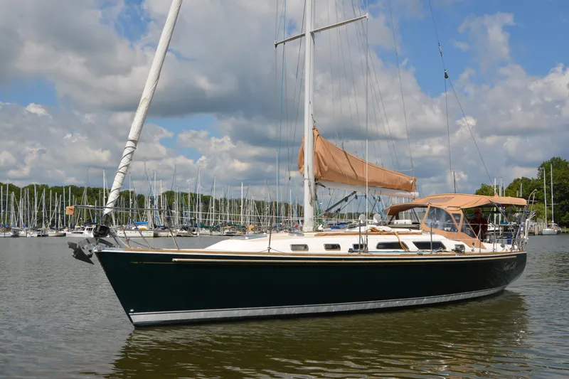 Slide: The Image of 2002 Sabre 402 sailboat docked in a marina under a partly cloudy sky. - 15