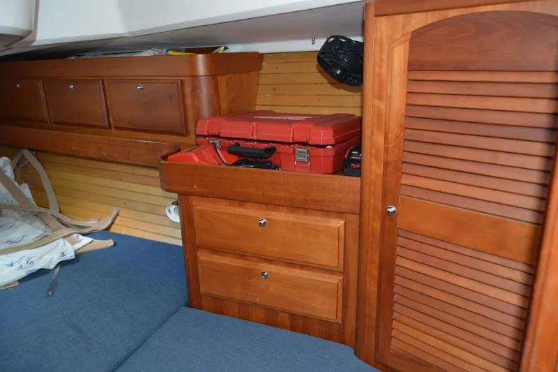 Slide: The Image of Interior of a 2002 Sabre 402 sailboat with wooden cabinetry and storage compartments. - 127