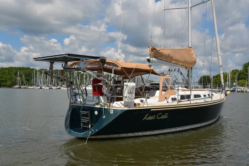 Slide: The Image of 2002 Sabre 402 sailboat named "Last Call" docked in a marina under a cloudy sky. - 6