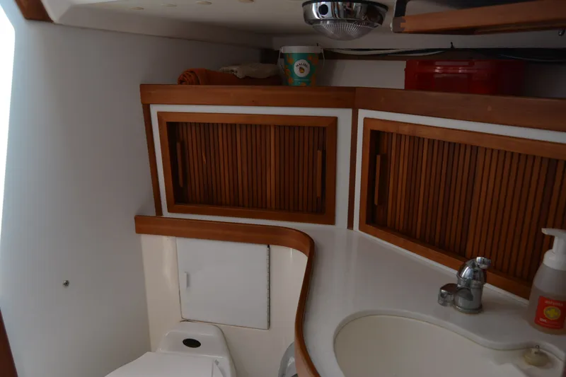 Slide: The Image of Interior of 2002 Sabre 402 yacht bathroom with wooden cabinets and sink. - 118