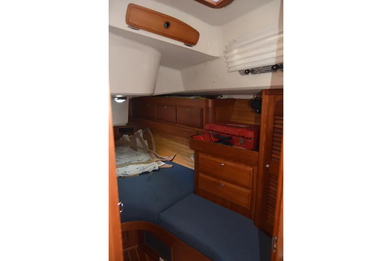 Slide: The Image of Cozy cabin interior of 2002 Sabre 402 sailboat with wooden storage and blue cushions. - 125