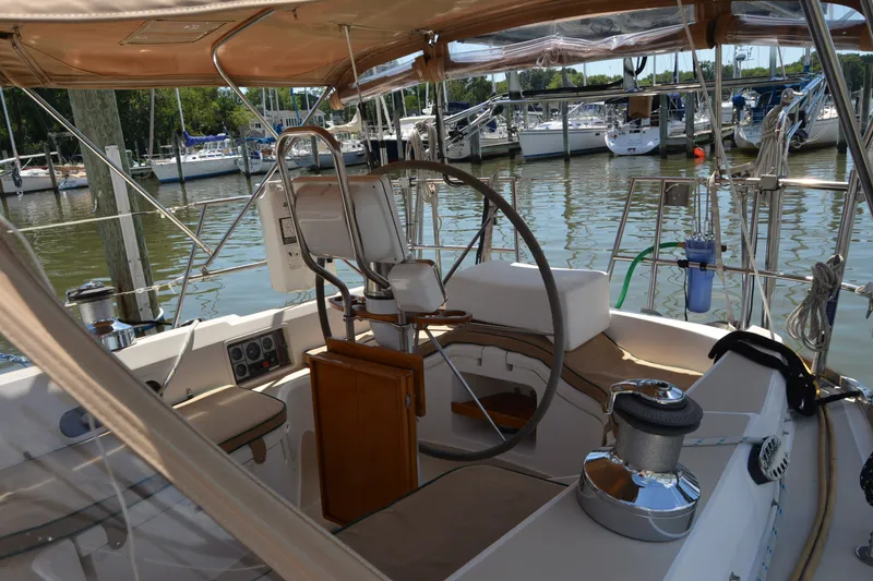 Slide: The Image of Cockpit of 2002 Sabre 402 sailboat docked at marina, featuring steering wheel and seating. - 53