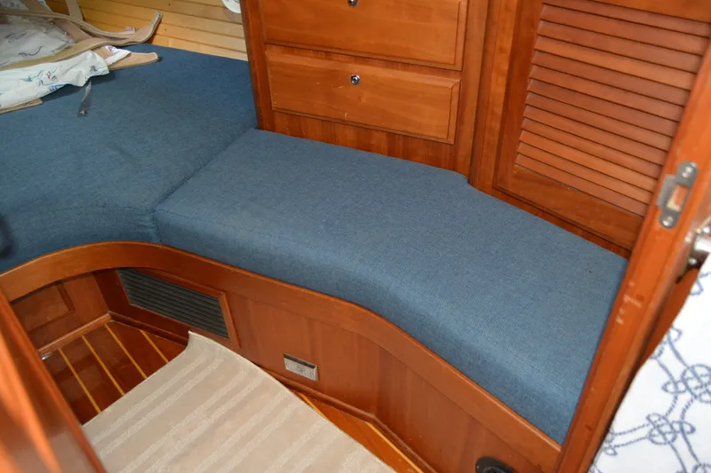 Slide: The Image of Interior of 2002 Sabre 402 yacht with blue cushioned seating and wooden cabinetry. - 128