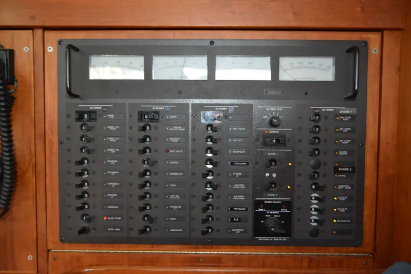 Slide: The Image of Electrical control panel on a 2002 Sabre 402 yacht, featuring various switches and gauges. - 111