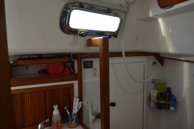 Slide: The Image of Interior of 2002 Sabre 402 sailboat bathroom with wooden accents and toiletries. - 117