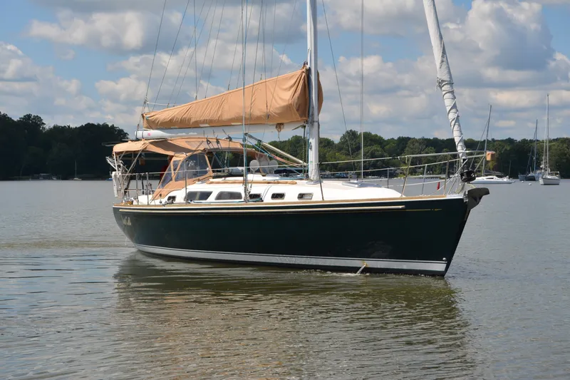 The Image of Sailing yacht Sabre 402, 2002 model, cruising on a calm lake under a partly cloudy sky. - 0