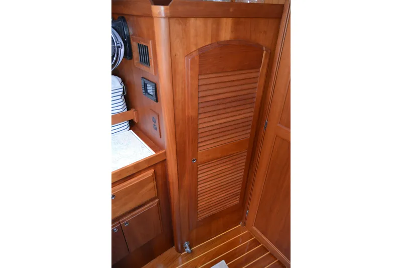 Slide: The Image of Wooden interior of 2002 Sabre 402 yacht, featuring cabinetry and louvered door. - 90
