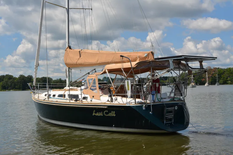 Slide: The Image of Sailing yacht "Last Call," Sabre 402, 2002 model, on a serene lake under a cloudy sky. - 18