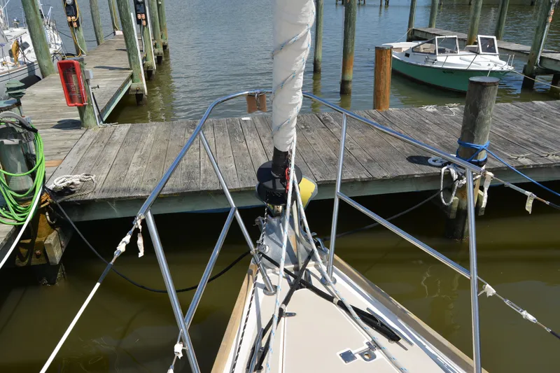 Slide: The Image of Bow of a 2002 Sabre 402 sailboat docked at a marina with wooden piers. - 29