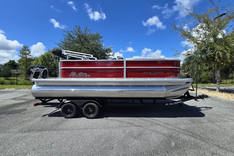 The Image of 2026 Sun Tracker Party Barge 20 DLX pontoon boat on trailer, parked outdoors. - 0