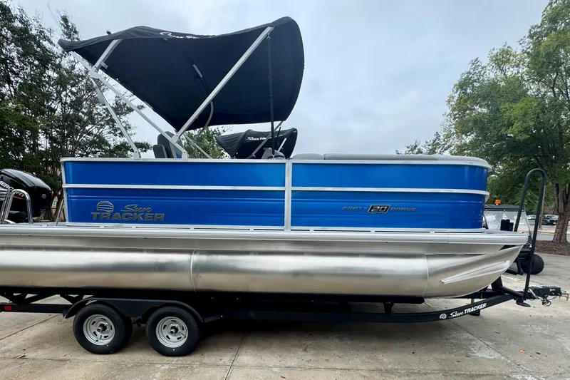 The Image of 2026 Sun Tracker Party Barge 20 DLX pontoon boat with blue exterior and canopy. - 0