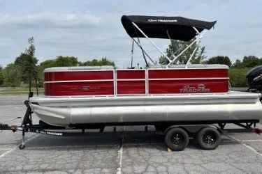 The Image of 2026 Sun Tracker Party Barge 20 DLX pontoon boat on trailer in parking lot. - 0