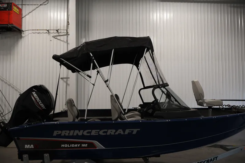 Slide: The Image of 2025 Princecraft Holiday 162 WS MAX boat with canopy in a warehouse setting. - 41