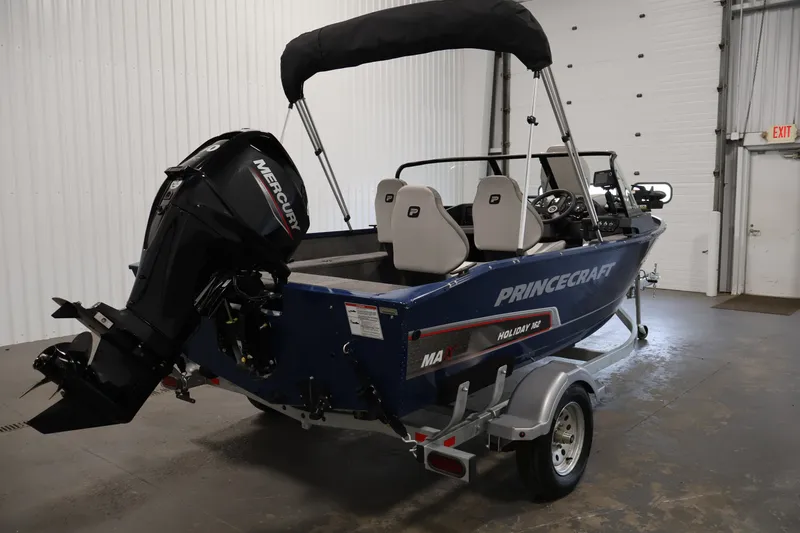 Slide: The Image of 2025 Princecraft Holiday 162 WS MAX boat with Mercury engine in a garage setting. - 5