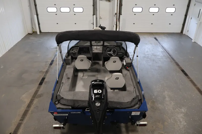 Slide: The Image of 2025 Princecraft Holiday 162 WS MAX boat in a garage, featuring a 60 HP Mercury engine. - 10