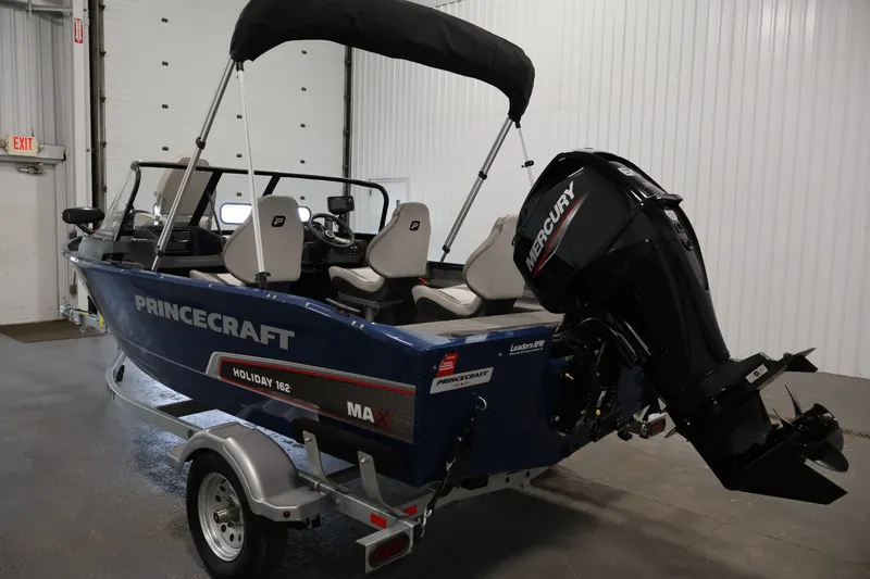 Slide: The Image of 2025 Princecraft Holiday 162 WS MAX boat with Mercury engine in a showroom. - 7