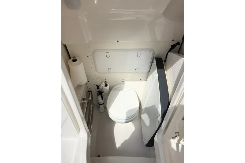 Slide: The Image of 2023 Robalo R272 Center Console boat interior with compact marine toilet. - 36