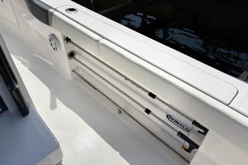 Slide: The Image of 2023 Robalo R272 Center Console boat interior with rod storage and speaker. - 19