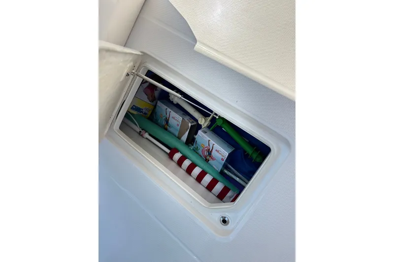 Slide: The Image of Storage compartment on 2023 Robalo R272 Center Console boat with pool noodles and inflatables. - 44