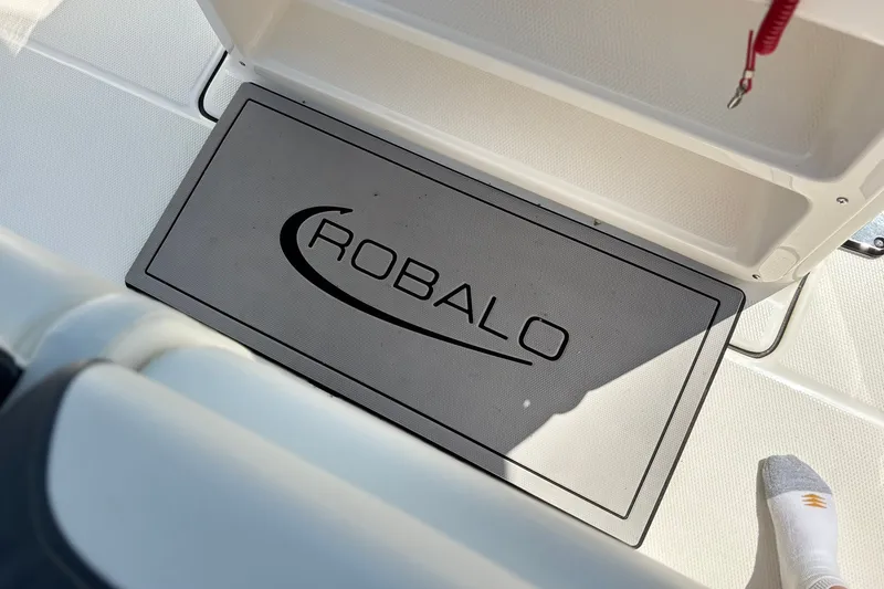 Slide: The Image of 2023 Robalo R272 Center Console boat deck with branded mat and foot visible. - 41