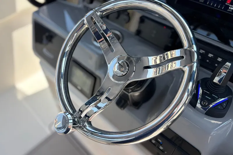 Slide: The Image of Steering wheel of 2023 Robalo R272 Center Console boat, showcasing sleek design and controls. - 35