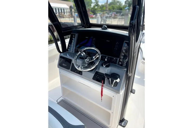 Slide: The Image of 2023 Robalo R272 Center Console helm with steering wheel and control panel. - 30
