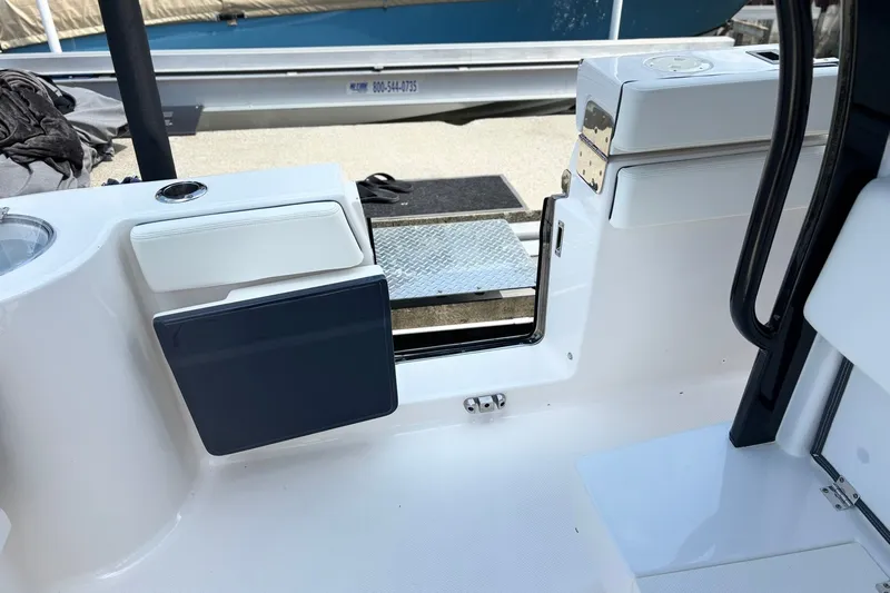 Slide: The Image of 2023 Robalo R272 Center Console boat interior with open side door and seating. - 15