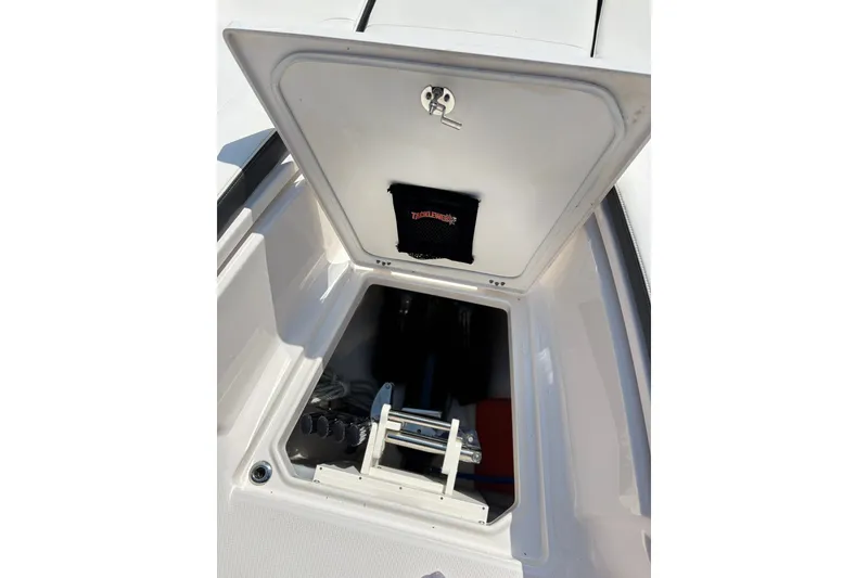 Slide: The Image of 2023 Robalo R272 Center Console storage compartment with open hatch and visible equipment. - 46