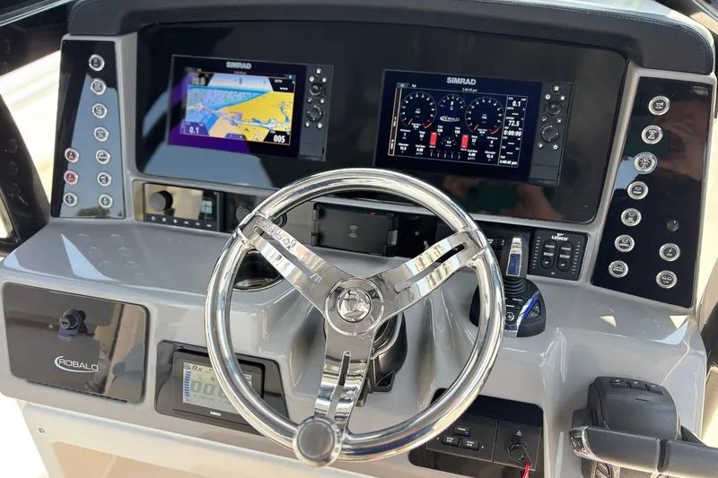 Slide: The Image of 2023 Robalo R272 Center Console dashboard with dual Simrad displays and steering wheel. - 31