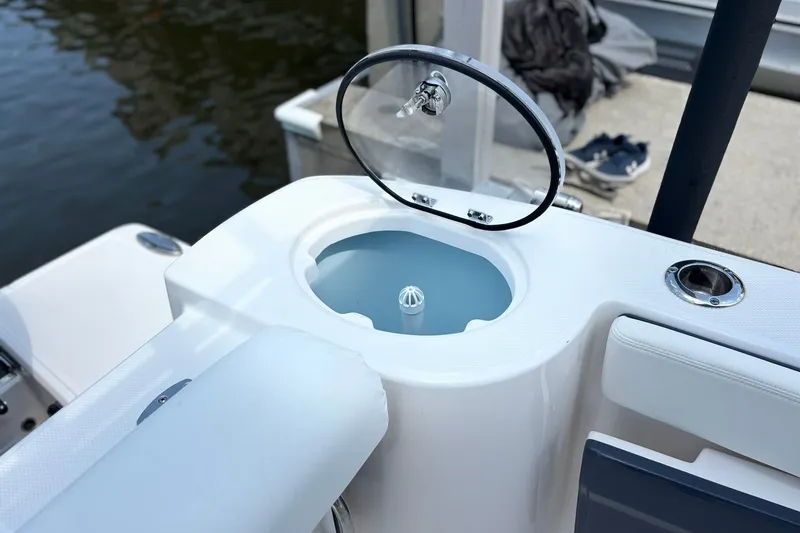 Slide: The Image of 2023 Robalo R272 Center Console boat with open livewell at dockside. - 22