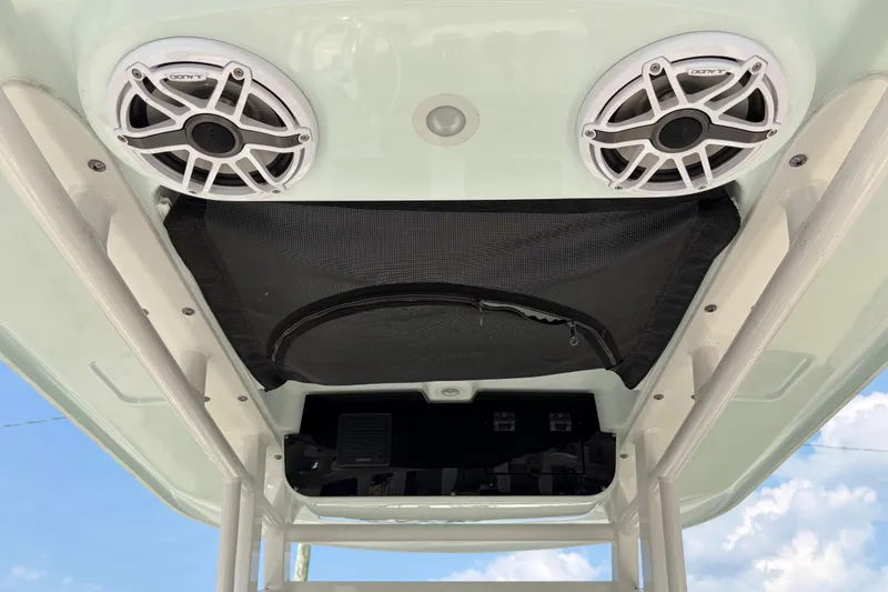 Slide: The Image of 2022 Edgewater 230CC boat speakers and storage compartment under canopy. - 21