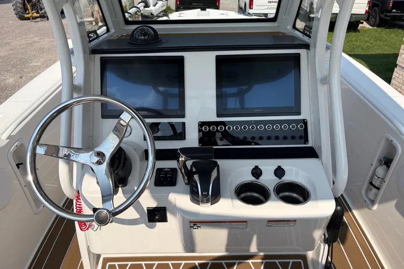 Slide: The Image of 2022 Edgewater 230CC boat console with dual screens, steering wheel, and controls. - 16