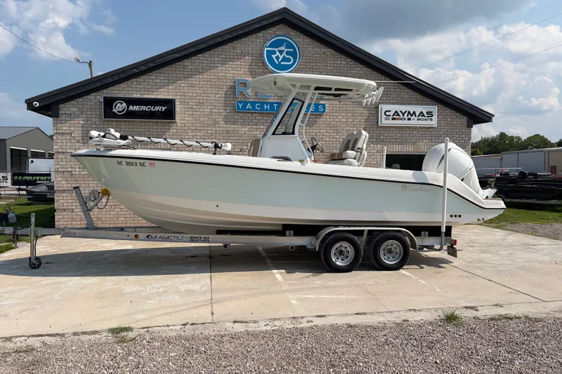 The Image of 2022 Edgewater 230CC boat on trailer at dealership, featuring modern design and dual engines. - 0